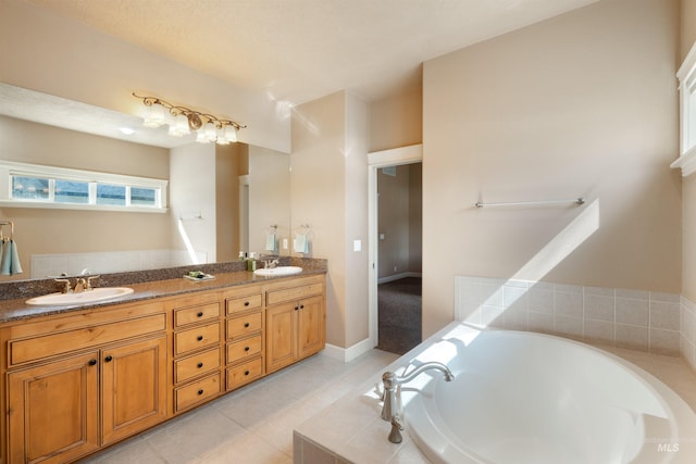 full bath with a bath, double vanity, a sink, and tile patterned floors