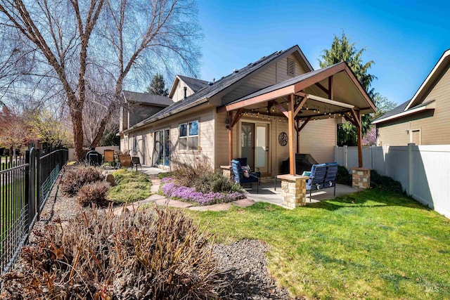 rear view of house featuring a patio, a gazebo, a fenced backyard, and a yard