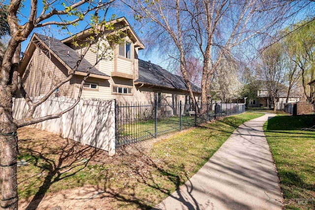 view of home's exterior with fence and a lawn
