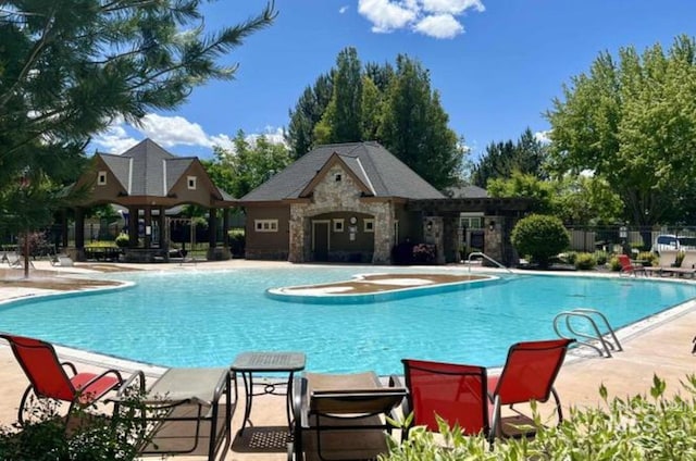 community pool featuring a patio and fence