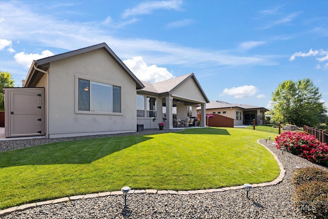 back of house featuring a yard and a storage shed