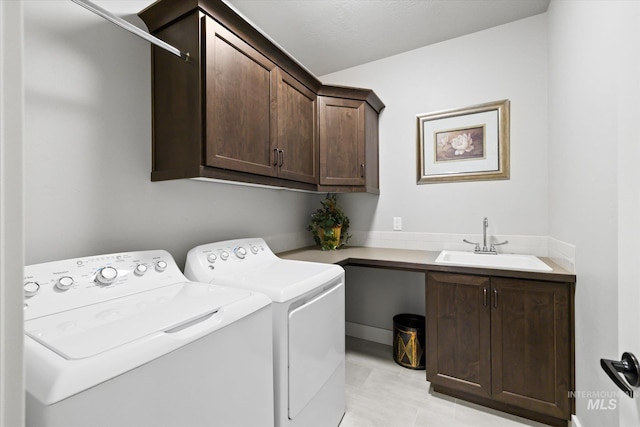 washroom with washer and dryer, cabinets, light tile patterned floors, and sink