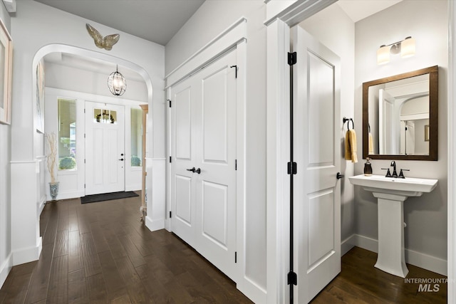 entrance foyer with dark hardwood / wood-style floors and a chandelier