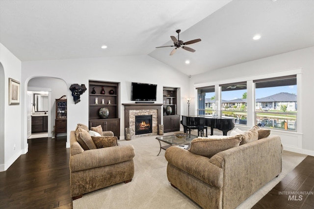 living room featuring ceiling fan, wood-type flooring, lofted ceiling, and a fireplace