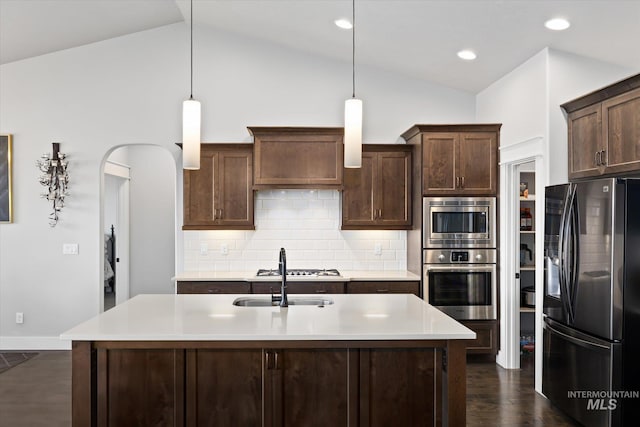 kitchen featuring dark brown cabinets, pendant lighting, lofted ceiling, and appliances with stainless steel finishes