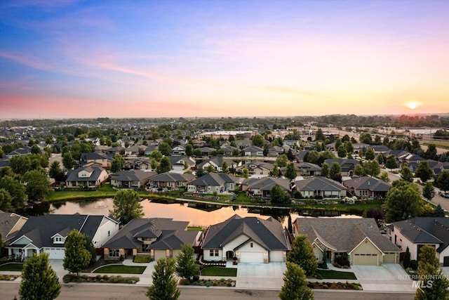 aerial view at dusk featuring a water view