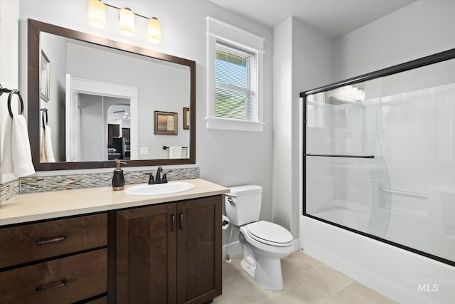 full bathroom featuring tile patterned flooring, vanity, toilet, and bath / shower combo with glass door