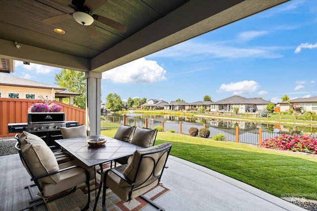 view of patio with a water view and ceiling fan