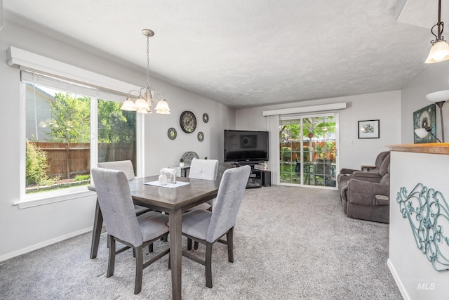 carpeted dining space featuring a chandelier and baseboards