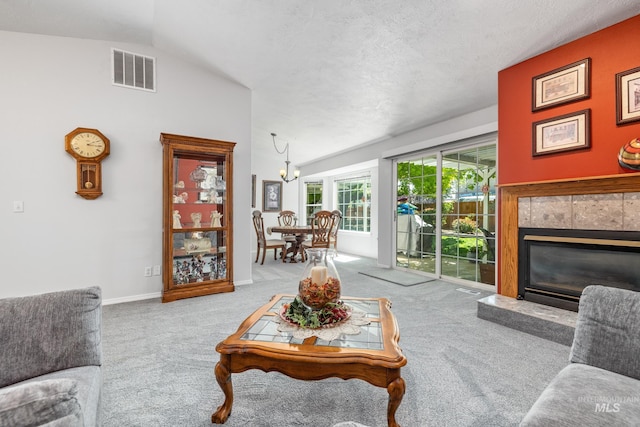 carpeted living room with vaulted ceiling, a tile fireplace, a chandelier, and baseboards