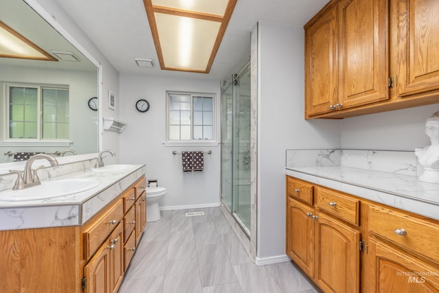 full bathroom with toilet, a shower stall, baseboards, and double vanity