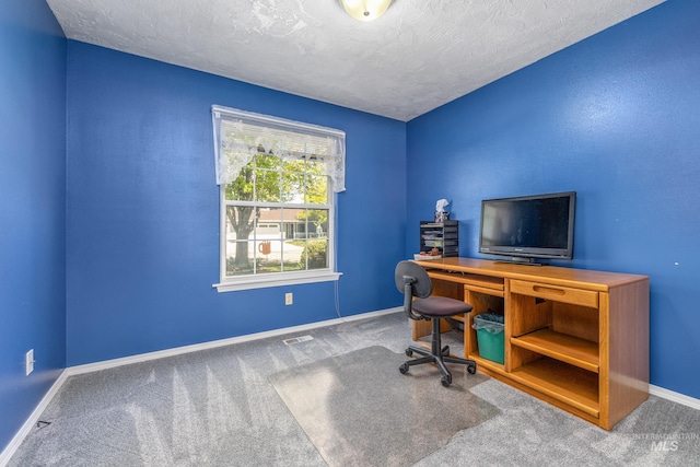 carpeted office space with baseboards and a textured ceiling