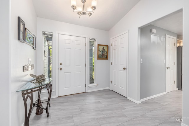 entrance foyer with a chandelier and baseboards