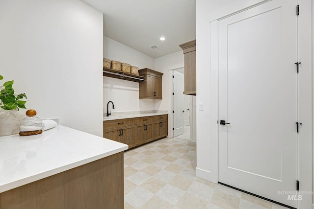 kitchen with visible vents, light floors, light countertops, recessed lighting, and a sink