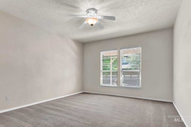 carpeted spare room with a textured ceiling, baseboards, and ceiling fan