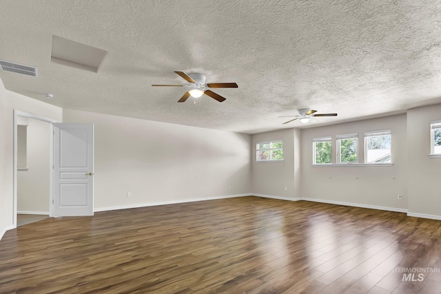 spare room with a textured ceiling, wood finished floors, ceiling fan, and baseboards