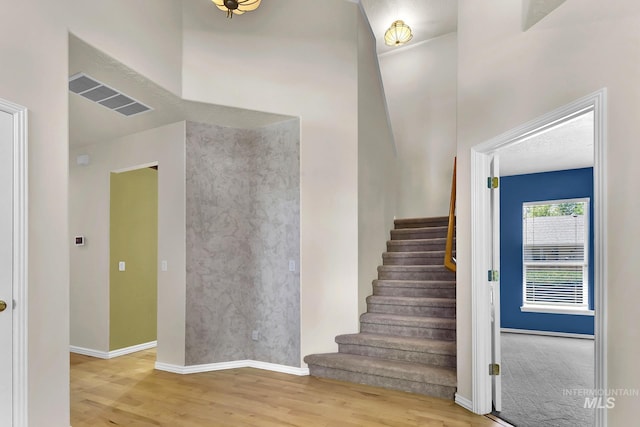 stairway with wood finished floors and baseboards