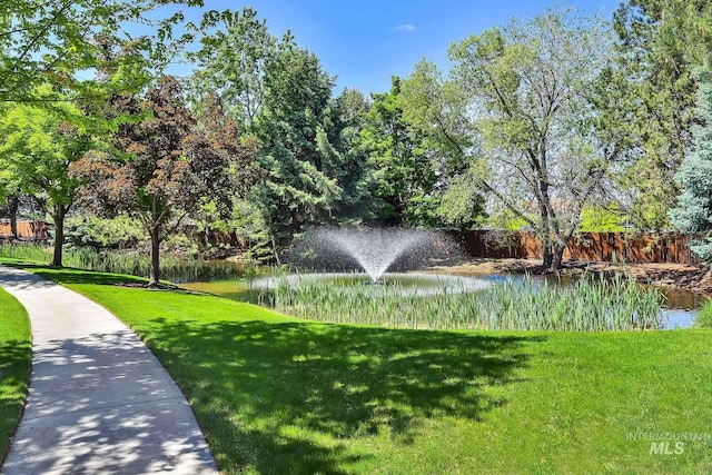 view of property's community featuring a yard and a water view