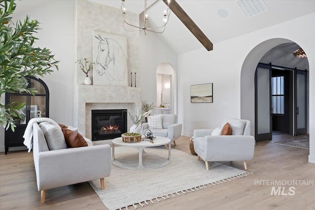 1948 Red Rock Way, Twin Falls, ID 83301 - living area with arched walkways, high vaulted ceiling, wood finished floors, a high end fireplace, and beam ceiling