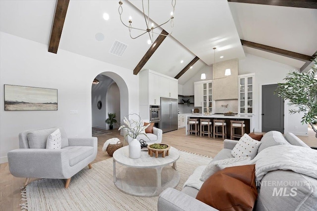 1948 Red Rock Way, Twin Falls, ID 83301 - living room featuring beam ceiling, high vaulted ceiling, arched walkways, light wood-style floors, and a chandelier