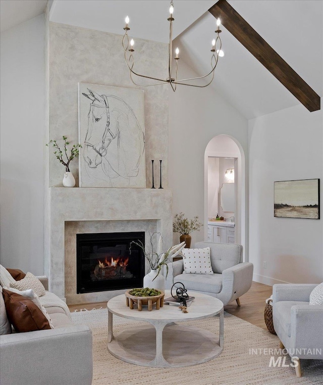 1948 Red Rock Way, Twin Falls, ID 83301 - living area featuring arched walkways, a high end fireplace, beamed ceiling, wood finished floors, and high vaulted ceiling