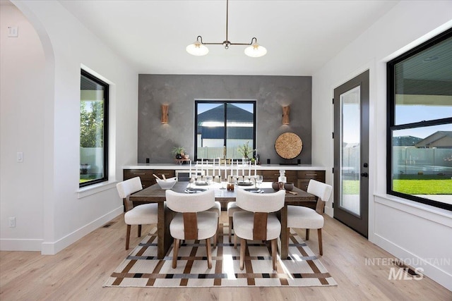 1948 Red Rock Way, Twin Falls, ID 83301 - dining area featuring light wood-style floors, plenty of natural light, arched walkways, and an accent wall