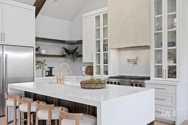 1948 Red Rock Way, Twin Falls, ID 83301 - kitchen featuring stainless steel appliances, backsplash, an island with sink, light stone counters, and vaulted ceiling