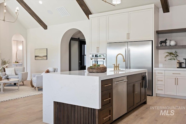 1948 Red Rock Way, Twin Falls, ID 83301 - kitchen featuring arched walkways, light wood-style flooring, white cabinets, and open floor plan