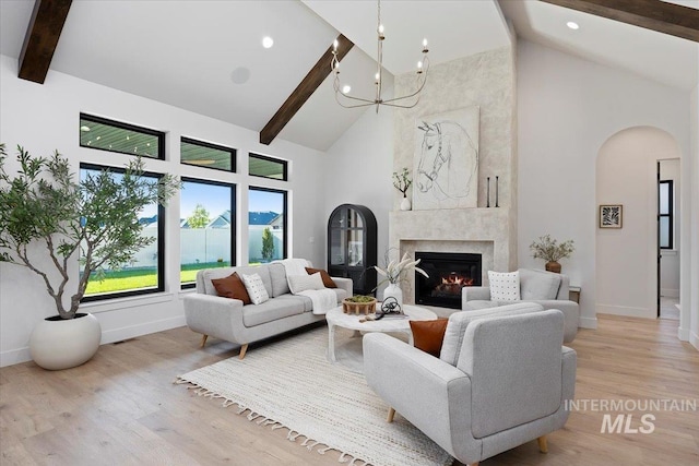 1948 Red Rock Way, Twin Falls, ID 83301 - living room with high vaulted ceiling, arched walkways, beamed ceiling, a chandelier, and light wood-style floors
