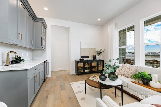 living area with light wood-type flooring, baseboards, and recessed lighting