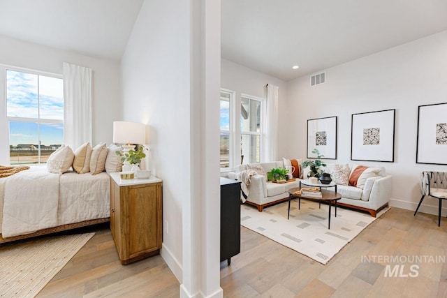 bedroom featuring light wood-type flooring, visible vents, and baseboards