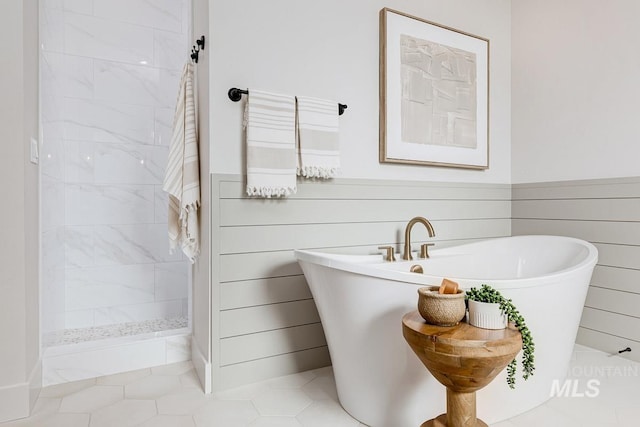 full bathroom with a freestanding tub, a walk in shower, and wainscoting