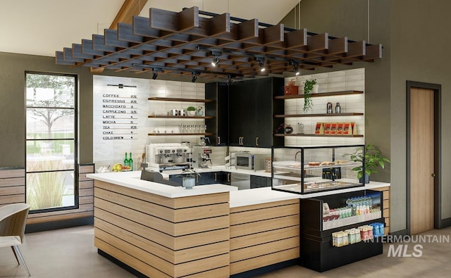 bar featuring stainless steel microwave and backsplash