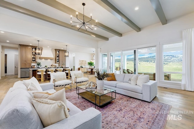 living area with an inviting chandelier, light wood-style flooring, beamed ceiling, and recessed lighting