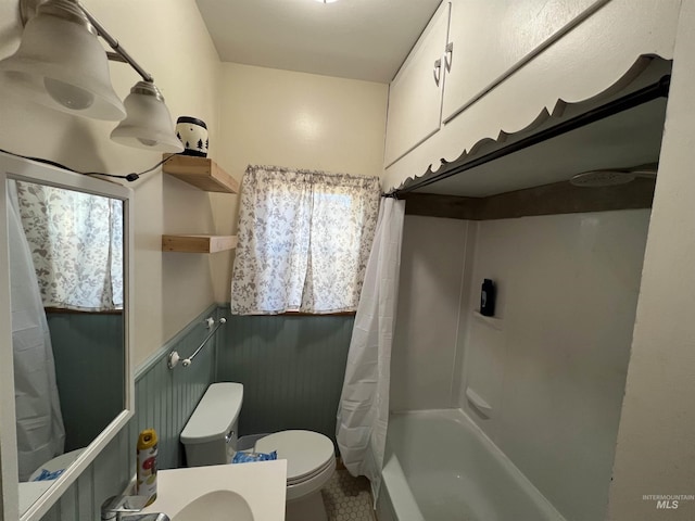 full bath with wainscoting, toilet, and shower / bathtub combination with curtain