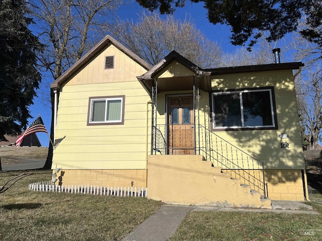 bungalow-style home featuring a front yard and crawl space