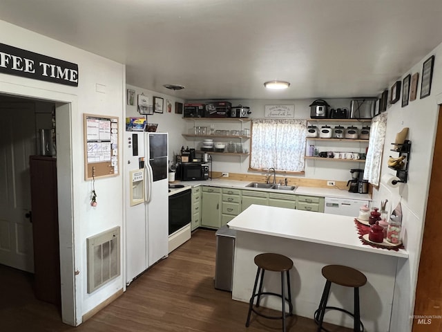 kitchen with white appliances, green cabinetry, light countertops, open shelves, and a sink