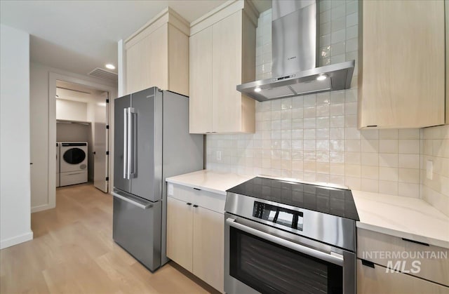 4340 E Haystack St Unit 101, Boise, ID 83716 - kitchen with wall chimney exhaust hood, washer / dryer, stainless steel appliances, light wood-type flooring, and recessed lighting