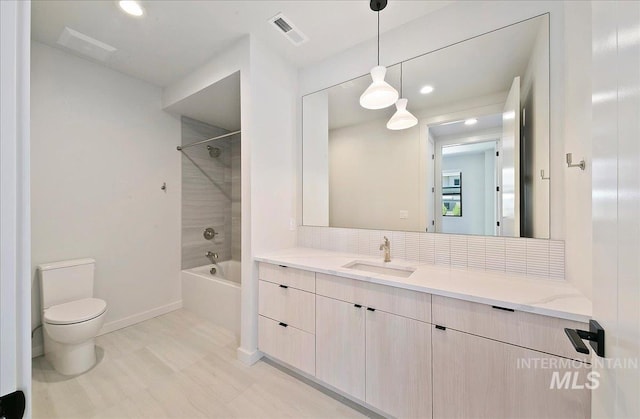 4340 E Haystack St Unit 101, Boise, ID 83716 - full bath featuring vanity, toilet, shower / tub combination, decorative backsplash, and baseboards