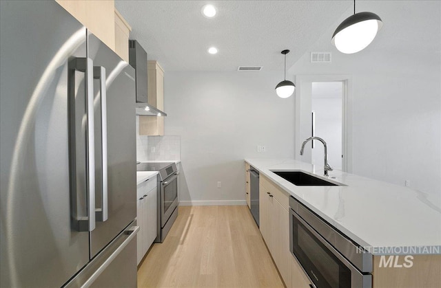 4340 E Haystack St Unit 101, Boise, ID 83716 - kitchen with stainless steel appliances, a sink, modern cabinets, light wood-style flooring, and a peninsula