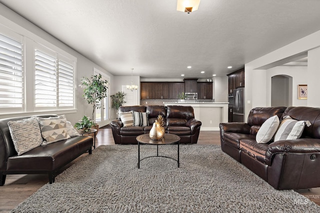 11153 W Brett Dr, Nampa, ID 83686 - living room with wood finished floors, a chandelier, recessed lighting, and arched walkways