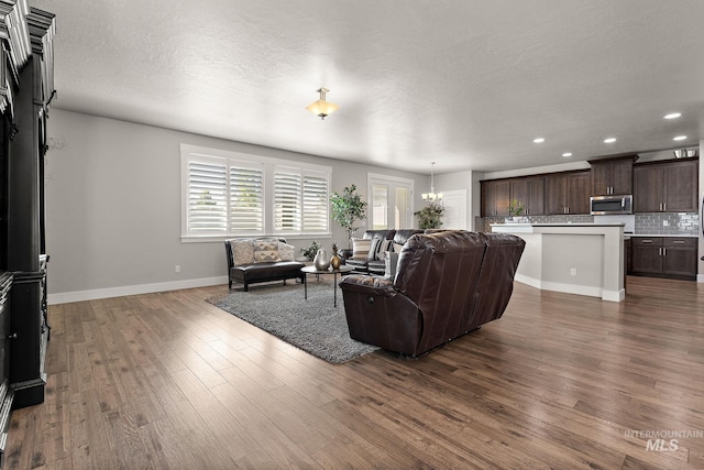 11153 W Brett Dr, Nampa, ID 83686 - living room with baseboards, dark wood-style flooring, a chandelier, recessed lighting, and a textured ceiling