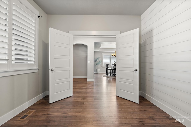 11153 W Brett Dr, Nampa, ID 83686 - unfurnished room featuring dark wood-type flooring, a chandelier, arched walkways, and baseboards