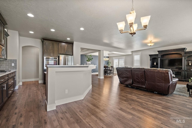 11153 W Brett Dr, Nampa, ID 83686 - living room featuring arched walkways, dark wood finished floors, a chandelier, a textured ceiling, and recessed lighting