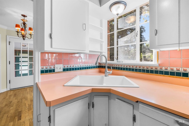 kitchen featuring decorative backsplash, dishwasher, light countertops, and a sink