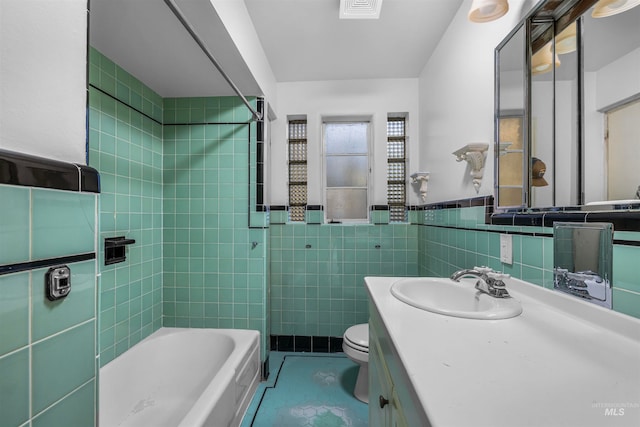 bathroom with tile patterned floors, visible vents, toilet, tile walls, and vanity