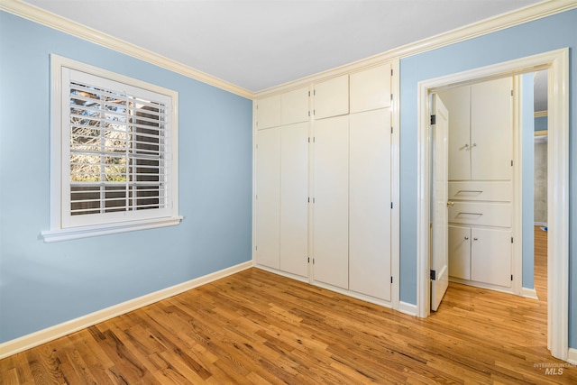 unfurnished bedroom featuring baseboards, light wood-style floors, a closet, and ornamental molding