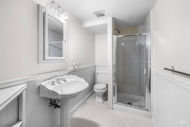 bathroom featuring visible vents, a shower stall, toilet, wainscoting, and tile patterned floors