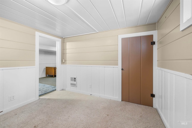 spare room featuring heating unit and carpet floors