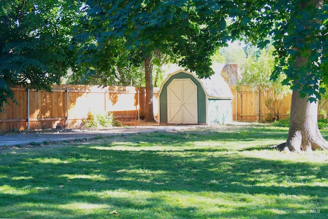 view of yard with an outbuilding, a storage unit, and a fenced backyard